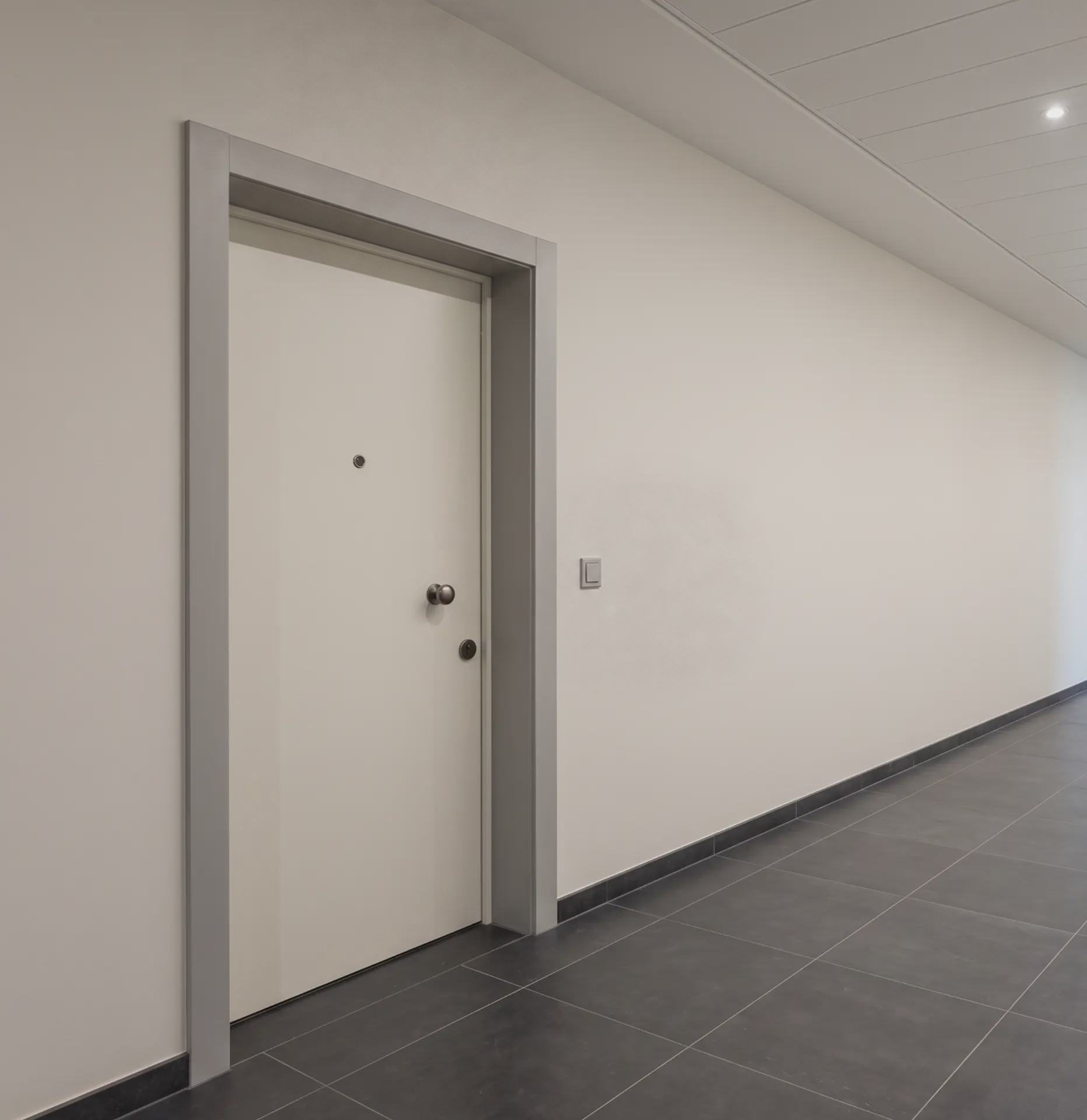 Inbraakwerende gepantserde deur EB Standaard in het wit met ronde knop en spion in een appartementsgang